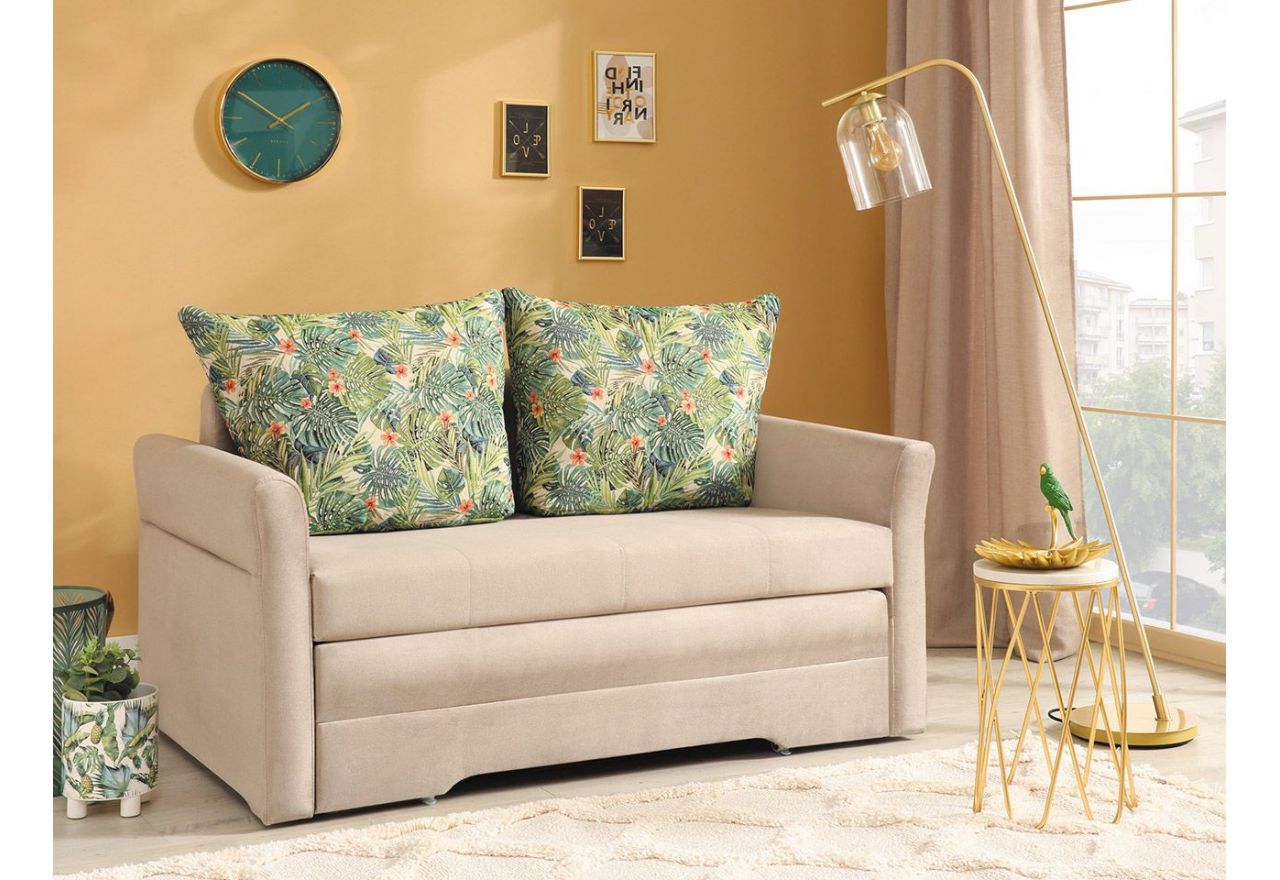 Welwetowa, dwuosobowa, beżowa sofa rozkładana CINTO z pojemnikiem na pościel i wzorzystymi poduszkami oparciowymi